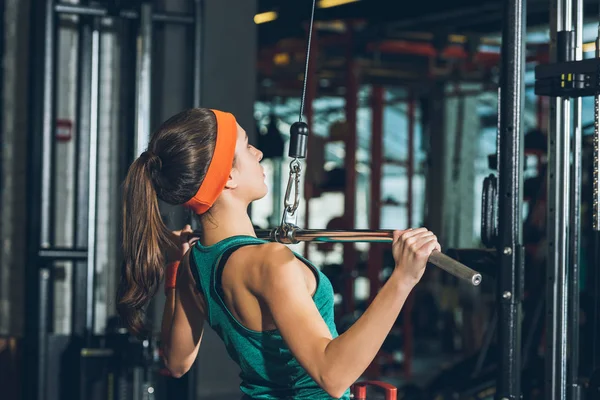 Спортивна жінка тренує груди на тренувальному апараті — стокове фото