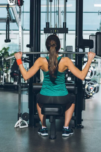 Mujer deportiva haciendo ejercicio en el aparato de entrenamiento - foto de stock