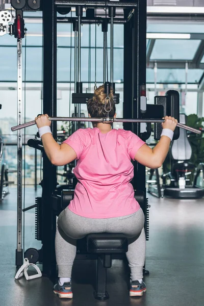 Mulher com excesso de peso trabalhando para fora no aparelho de formação no ginásio — Fotografia de Stock