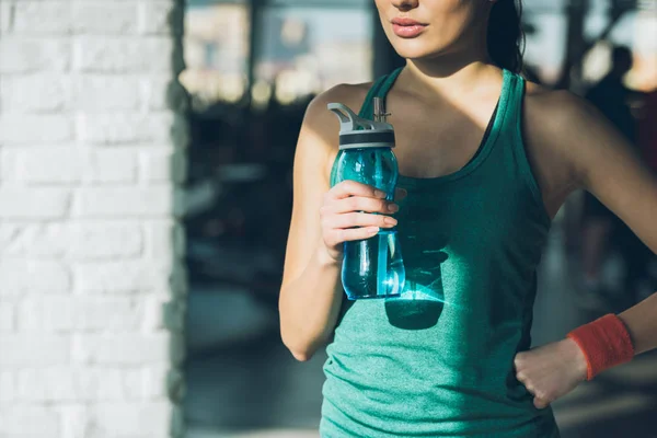 Immagine ritagliata di donna sportiva in possesso di una bottiglia d'acqua — Foto stock