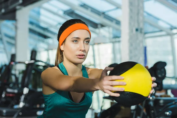 Allenamento femminile sportivo con palla medica in palestra — Foto stock