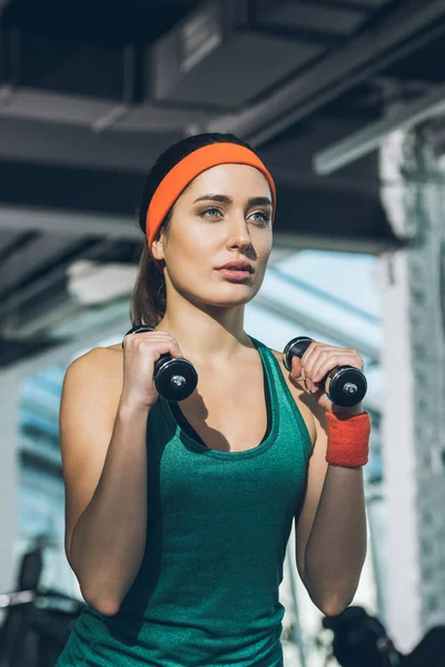 Allenamento di donna sportiva con manubri in palestra — Foto stock