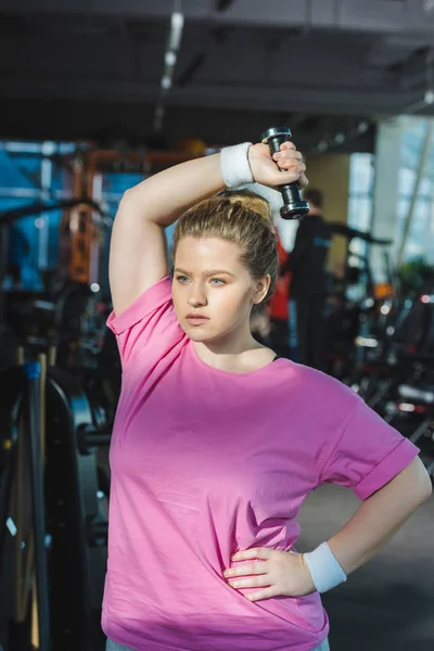 Allenamento donna in sovrappeso con manubri in palestra — Foto stock