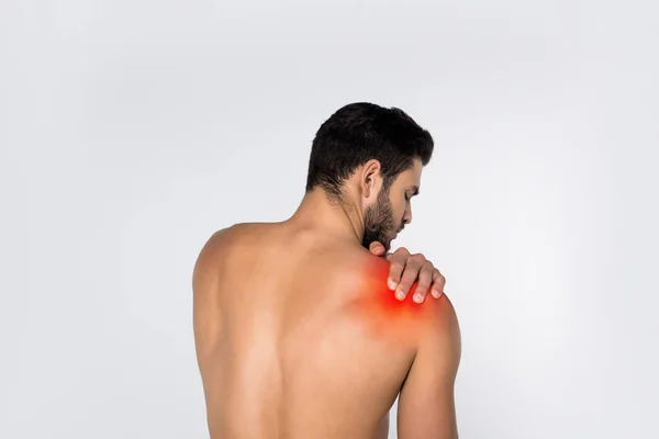 Vue arrière du jeune homme torse nu avec douleur à l'épaule isolé sur blanc — Photo de stock