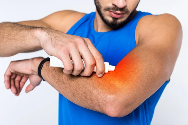 Inyección recortada de hombre aplicando ungüento en el brazo mientras tiene dolor en el brazo - foto de stock