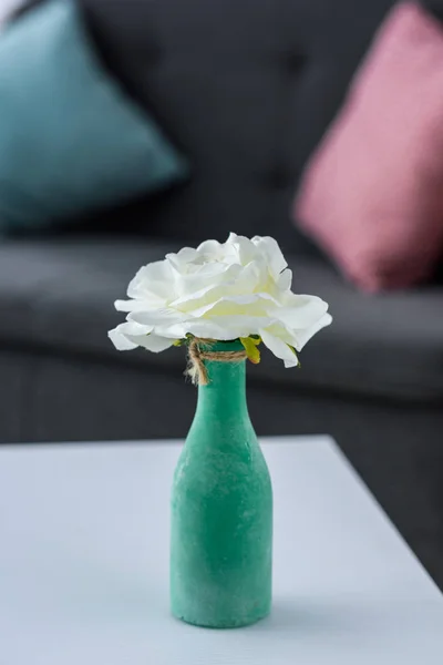 Vista de cerca de la flor en jarrón en la mesa de café en la sala de estar - foto de stock
