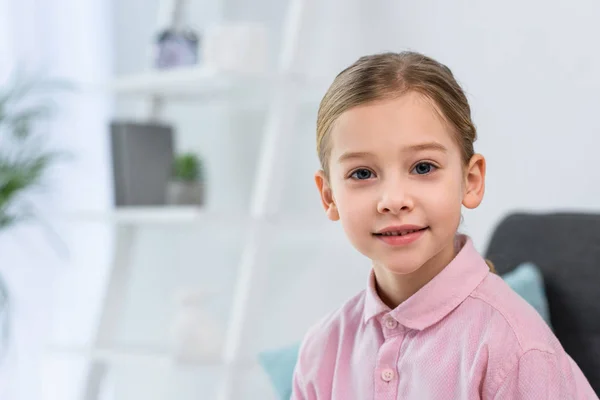 Portrait of pretty little child in pink shirt looking at camera at home — Stock Photo