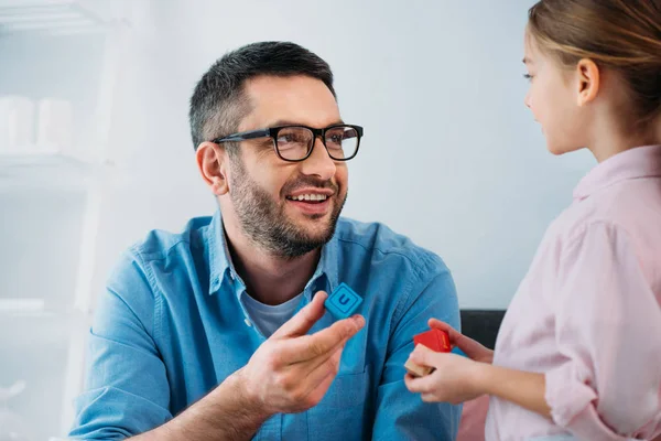 Smiling father and daughter with colorful blocks in hands — Stock Photo