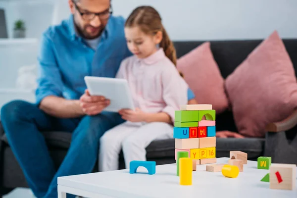 Селективное внимание отца и дочери с помощью планшета вместе дома — Stock Photo