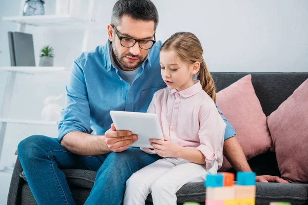 Portrait of father and daughter using tablet together at home — Stock Photo