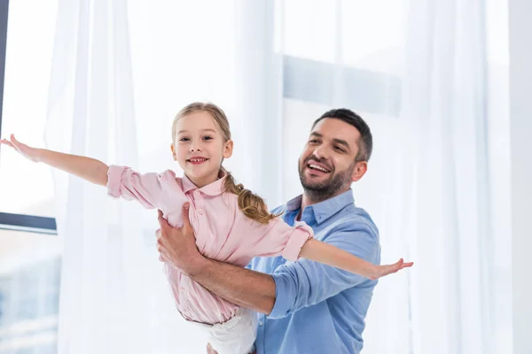 Portrait of happy father playing with little daughter at home — Stock Photo