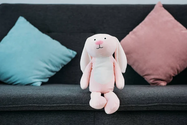 Vista de cerca de juguete infantil rosa en el sofá - foto de stock