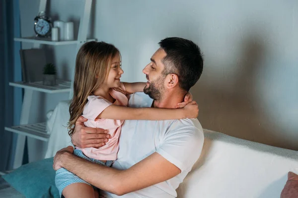 Visão lateral de pai e filha sorrindo olhando um para o outro em casa — Fotografia de Stock