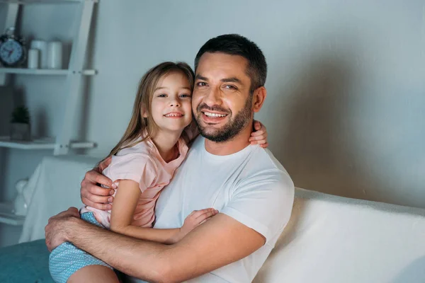 Porträt eines lächelnden Vaters und seiner Tochter, die zu Hause in die Kamera schauen — Stockfoto