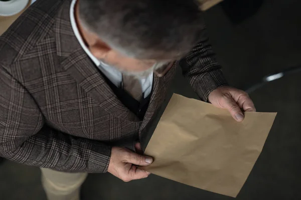 High angle view of senior man in tweed suit reading letter — Stock Photo