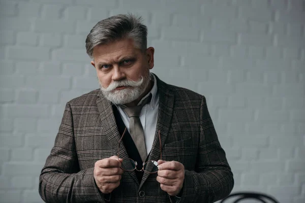 Serious senior man in tweed suit looking at camera — Stock Photo