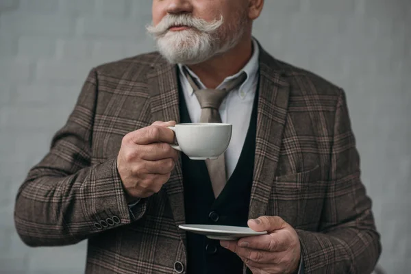 Recortado tiro de hombre mayor con taza de café - foto de stock