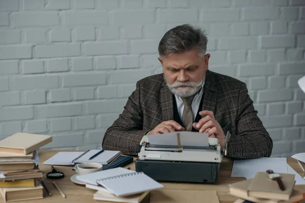 Escritor sênior bonito em terno tweed trabalhando com máquina de escrever — Fotografia de Stock