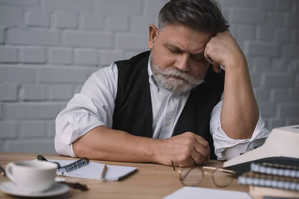 Écrivain senior fatigué dormir sur le lieu de travail — Photo de stock