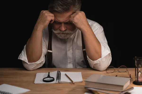 Deprimido escritor senior sentado en el lugar de trabajo con manuscrito en blanco — Stock Photo