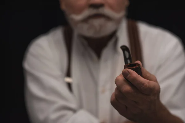 Cropped shot of bearded senior man smoking pipe — Stock Photo