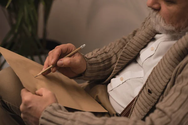 Close-up shot of bearded senior man writing letter — Stock Photo