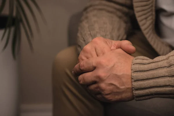 Обрізаний знімок старшого чоловіка тримає своїми руками — стокове фото