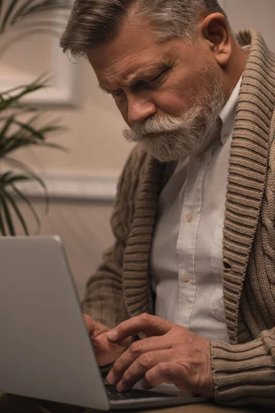 Primer plano de hombre mayor utilizando el ordenador portátil - foto de stock