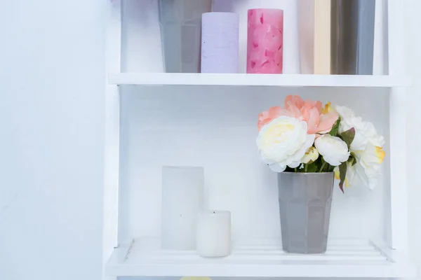 Vista close-up de prateleiras de madeira branca com livros, velas e flores em vaso — Fotografia de Stock