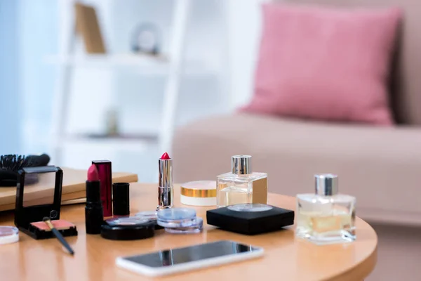Close-up view of smartphone and various cosmetics on table — Stock Photo