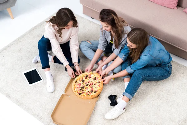 Blick aus der Vogelperspektive auf schöne junge Frauen, die zu Hause Pizza essen — Stockfoto