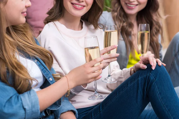 Schnappschuss von schönen lächelnden Freundinnen, die miteinander reden und Champagner trinken — Stockfoto