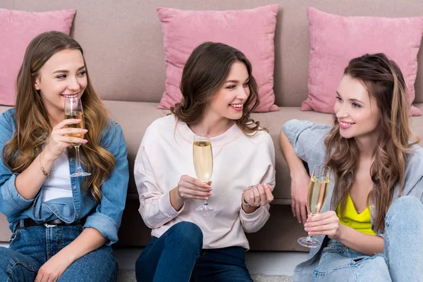 Belles jeunes femmes souriantes parlant et buvant du champagne ensemble — Photo de stock