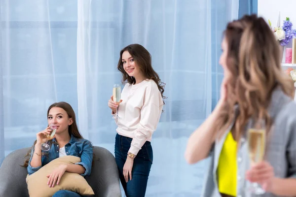 Bela sorrindo jovens mulheres bebendo champanhe e falando — Fotografia de Stock