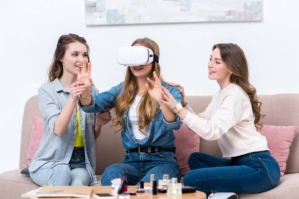 Smiling young girlfriends having fun together with virtual reality headset — Stock Photo