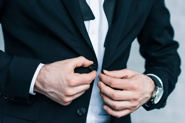 Vista parcial de hombre de negocios buttoning chaqueta - foto de stock