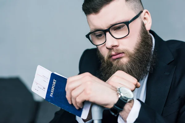 Porträt eines nachdenklichen Geschäftsmannes mit Pass und Ticket in der Hand — Stockfoto