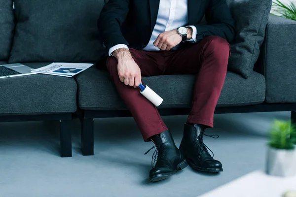 Plan recadré de pantalon de nettoyage homme d'affaires avec brosse collante — Photo de stock