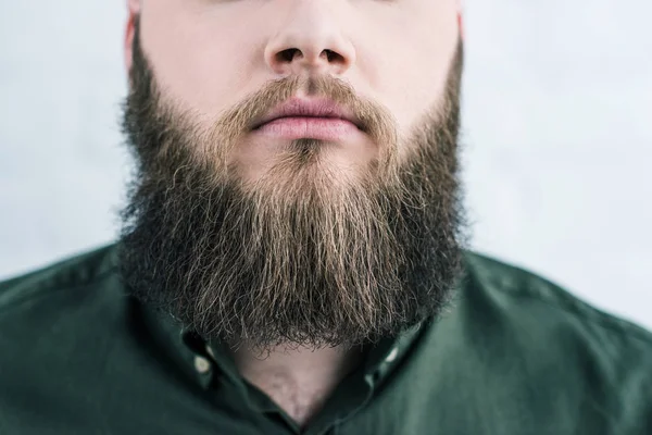 Обрезанный снимок бородатого мужчины в рубашке на стене из белого кирпича — стоковое фото
