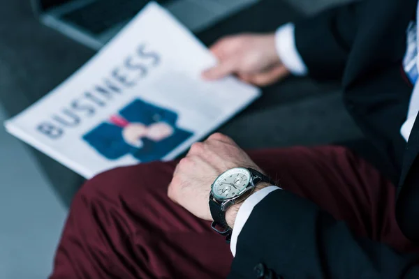 Partial view of businessman with business newspaper on sofa — Stock Photo