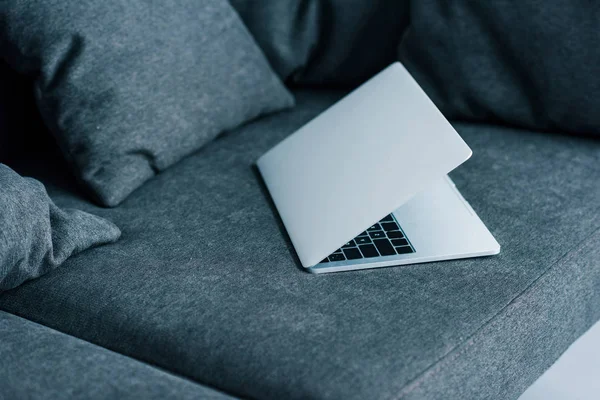 Vista da vicino del computer portatile sul divano grigio — Foto stock