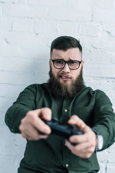 Избирательный фокус бородатого бизнесмена с геймпадом в руках — стоковое фото