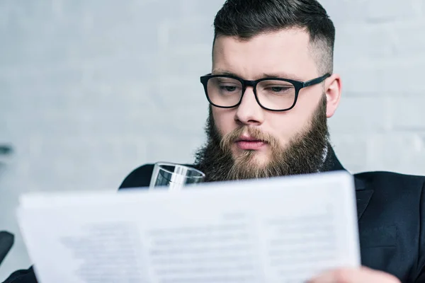 Selective focus of focused businessman in eyeglasses reading newspaper — Stock Photo