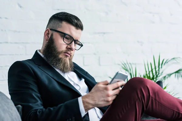 Stylish focused businessman using smartphone — Stock Photo