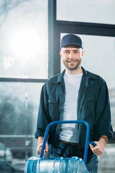 Loader holding delivery cart with water bottles — Stock Photo