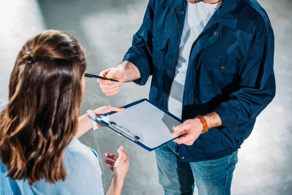 Delivery man handling woman a cargo declaration — Stock Photo