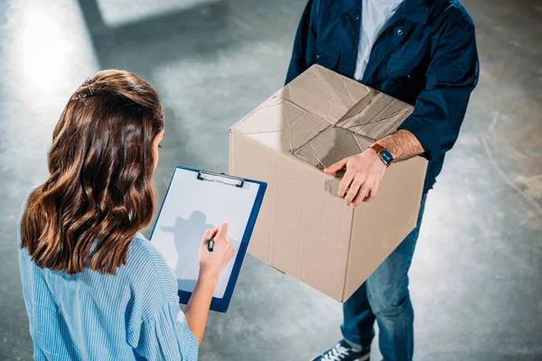 Kurier hält Kiste, während Frau Fracht-Erklärung seufzt — Stockfoto