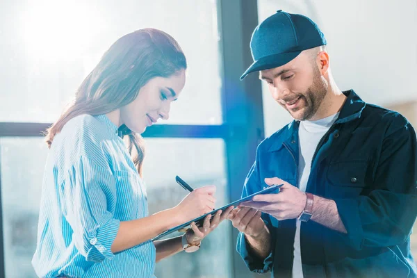 Consegna uomo e donna guardando la dichiarazione di carico — Foto stock