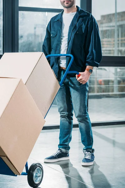 Close-up view of courier holding hand truck — Stock Photo