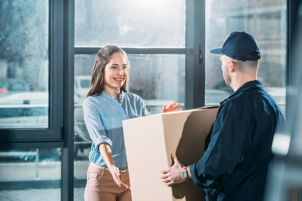 Mujer recibiendo paquete de repartidor hombre - foto de stock